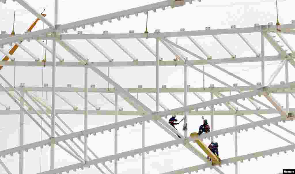 Para pekerja memperbaiki atap stadion sepakbola &quot;Itaquerao&quot; di Sao Paulo, Brazil yang akan menjadi tuan rumah pertandingan pembukaan Piala Dunia 2014.