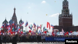People walk with flags and banners at Red Square during a May Day rally in Moscow, Russia, May 1, 2016.