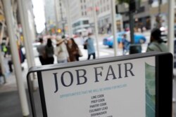 FILE - Signage for a job fair is seen on 5th Avenue in Manhattan, New York City, Sept. 3, 2021.