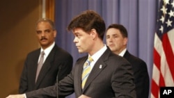 Attorney General Eric Holder, left, listens as U.S. Immigration and Customs Enforcement Assistant Secretary John Morton speaks during a news conference at the Justice Department in Washington, 10 June 2010