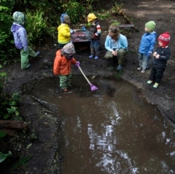 These children at Cedarsong Nature School on Vashon Island, near Seattle, Washington, are playing in a puddle. (AP Photo/Ted S. Warren, 2010)