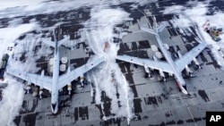 In this image taken from video provided by the Russian Defense Ministry Press Service, a pair of Tu-95 strategic bombers of the Russian air force are parked at an air base in Engels near the Volga River in Russia, Monday, Jan. 24, 2022. (Russian Defense M
