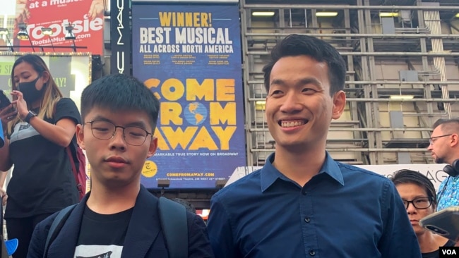 梁繼平(右)9月15日與黃之鋒一起到紐約時報廣場高唱榮光歸香港的歌曲。(美國之音中文部)