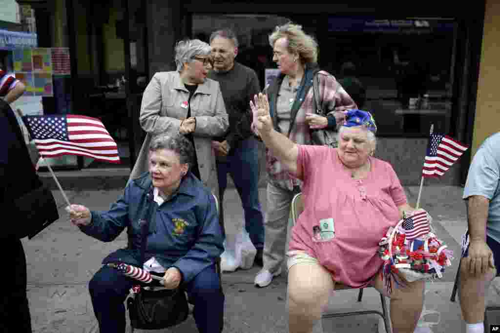 Jane Wick, left, and Mary Ann Chubirka wave flags while watching the College Point Memorial Day Parade in New York, May 26, 2013. 