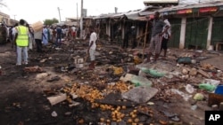 FILE - People gather at the scene of a car bomb explosion at the central market in Maiduguri, Nigeria, July 2, 2014.