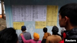 Warga desa dan para kerabat memeriksa daftar nama penumpang yang masih hilang dalam kecelakaan feri di Danau Toba, Simalungun, Sumatra Utara, 20 Juni 2018.