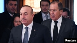 Russian Foreign Minister Sergei Lavrov, right, and his Turkish counterpart, Mevlut Cavusoglu, enter a hall as they meet in Moscow, Russia, Dec. 20, 2016. 