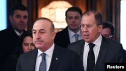 Russian Foreign Minister Sergey Lavrov, right, and his Turkish counterpart, Mevlut Cavusoglu, enter a hall as they meet in Moscow, Russia, Dec. 20, 2016.