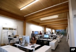 FILE - An upper floor of Lever Architecture headquarters, a four-story all-wood building built using cross-laminated timber stands in Portland, Ore., Nov. 15, 2016.