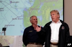 FILE - President Donald Trump speaks to first responders as he visits the Horry County Emergency Management center in the area impacted by Hurricane Florence, Sept. 19, 2018, in Conway, South Carolina, as the state's governor, Henry McMaster, listens. Wednesday saw the test of a new presidential alert system which will be used to inform Americans about national emergencies.