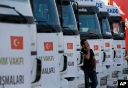 A driver waits in front of trucks carrying humanitarian aid destined for Idlib, Syria, by a Turkish pro-government aid group, prior to their departure in Istanbul, Sept. 10, 2018.