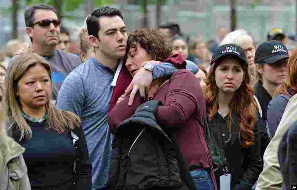 Two people embrace on the plaza of the National September 11 Memorial in New York to watch the telecast of the dedication ceremony.
