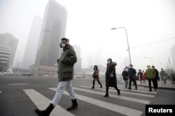 지난 2016년 스모그가 가득한 중국 베이징의 거리에서 방독면이나 방진 마스크를 착용한 시민들이 횡단보도를 지나고 있다.