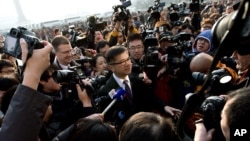 U.S. Ambassador to China Gary Locke, center, is mobbed by journalists as he attends the opening session of the annual National People's Congress at the Great Hall of the People in Beijing, China, Mar. 5, 2013. 