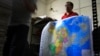 FILE - A worker holds a new officially approved map of China that includes the islands and maritime area that Beijing claims in the South China Sea, at a printing factory in Changsha in south China's Hunan province.