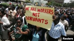 FILE - Zimbabwe's civil servants carry placards as they march during a protest in the streets of the capital Harare, Feb. 19, 2010. 