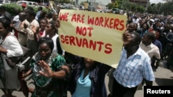 FILE - Zimbabwe's civil servants carry placards as they march during a protest in the streets of the capital Harare. 