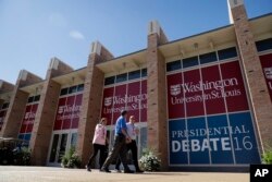 People walk by the second presidential debate site at Washington University in St. Louis, Missouri, Oct. 8, 2016.