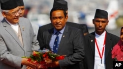 FILE - Maldives President Abdullah Yameen, center, is welcomed at Tribhuwan Airport to attend the South Asian Association for Regional Cooperation summit in Katmandu, Nepal, Nov. 25, 2014.