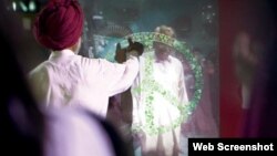 This screenshot from Coca-Cola's short film "Small World Machines" shows two men from India and Pakistan reaching out to each other through high-tech touchscreens in Lahore and New Delhi.