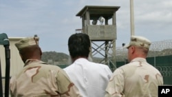 Un prisonnier escorté par des gardes à Guantanamo