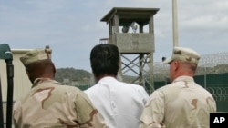 Un prisonnier escorté par des gardes à Guantanamo 