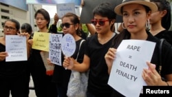 FILE - Thai social media users hold banners during a rally calling for the death penalty for rapists, outside a shopping mall in Bangkok, July 12, 2014.