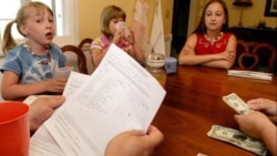 Three sisters in Ohio wait as their parents count out their allowances and look over the list of the children' chores