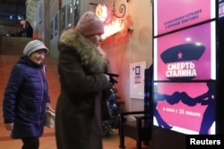 People walk past a poster of the movie "Death of Stalin" at a cinema in Moscow, Russia. Picture taken Jan. 22, 2018.