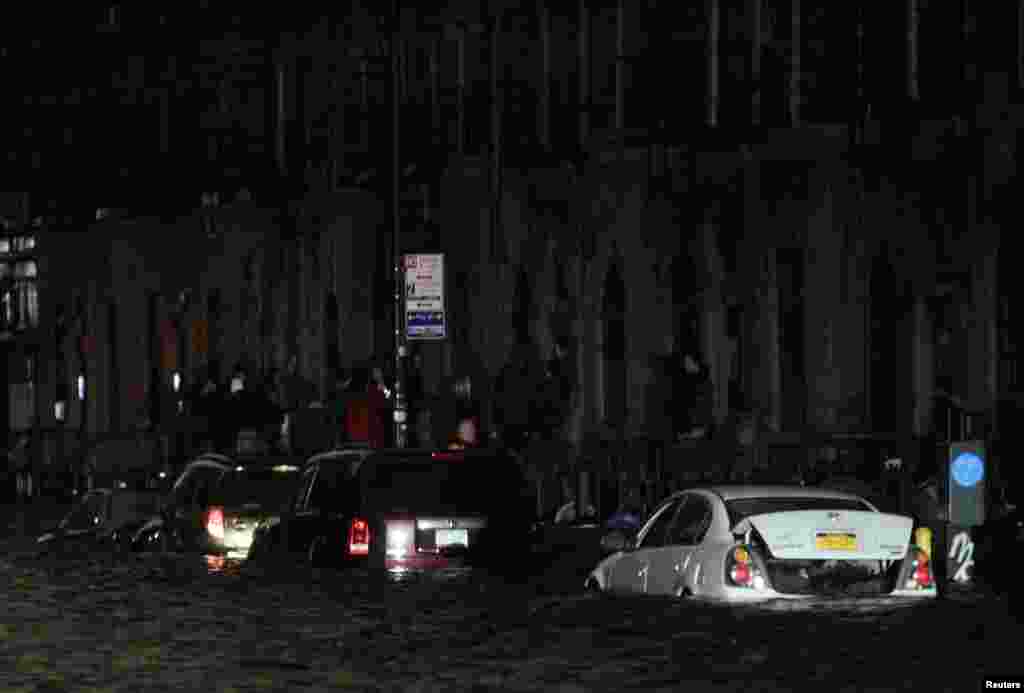 Flood waters brought on by Hurricane Sandy over run cars in New York's lower east side, October 29, 2012. Hurricane Sandy began battering the U.S. East Coast on Monday with fierce winds and driving rain, as the monster storm shut down transportation, shut