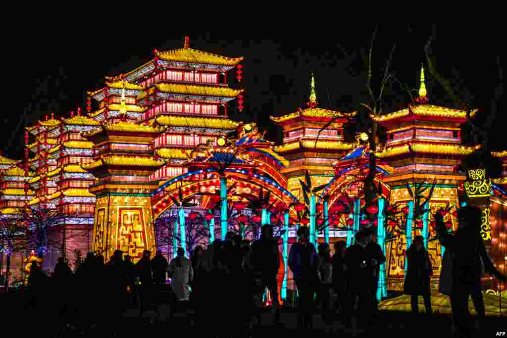 Visitors look at silk lanterns set up at the Foucaud Park in Gaillac, France, during the Lantern Festival, Dec. 12, 2018.