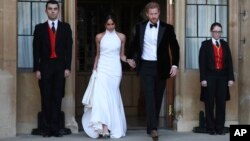 Pengantin baru Duke dan Duchess of Sussex, Meghan Markle dan Pangeran Harry, meninggalkan Puri Windsor setelah upacara pernikahan untuk menghadiri resepsi pernikahan di Frogmore House, yang diadakan Pangeran Charles, 19 Mei 2018. 