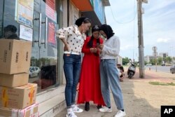 In this June 5, 2019, photo, women from the the Hui Muslim ethnic minority from a nearby neighborhood gather outside a shop near an OFILM factory in Nanchang in eastern China's Jiangxi province. (AP Photo/Ng Han Guan)