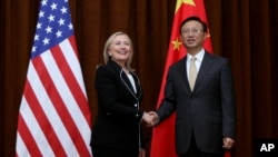 U.S. Secretary of State Hillary Rodham Clinton, left, and Chinese Foreign Minister Yang Jiechi, right, shake hands during her visit to Beijing, Sept. 4, 2012. 