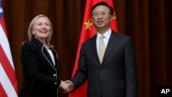 U.S. Secretary of State Hillary Rodham Clinton, left, and Chinese Foreign Minister Yang Jiechi, right, shake hands during her visit to Beijing, Sept. 4, 2012.