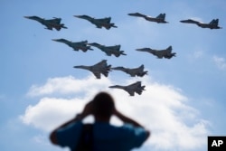 FILE - A man watches Russian military jets performing in Alabino, outside Moscow, Russia, Aug. 12, 2017. Russia's planned ‘Zapad 2017’ exercises on the border with Baltic states and Poland are viewed with suspicion by NATO alliance members.