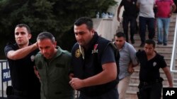 FILE - Members of Turkey's armed forces are escorted by police for their suspected involvement in an attempted coup, at the court house in Mugla, Turkey, July 17, 2016. A Greek court on Tuesday approved the extradition of three Turkish soldiers who fled to Greece following the failed putsch. 
