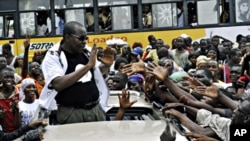 Malian-born Ivorian comic and presidential candidate Adama Dolo greets people from an open-deck car during an election campaign in Abidjan, 20 Oct. 2010