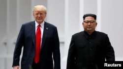 Archivo - El presidente de Estados Unidos, Donald Trump y el líder norcoreano Kim Jong Un caminan después de su encuentro en la isla Sentosa, en Singapur el 12 de junio del 2018