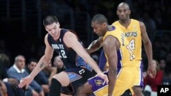 Pemain Lakers dari Los Angeles, Metta World Peace (tengah) merebut bola dari pemain Charlotte Bobcats, Byron Mullens (kiri). Kobe Bryant mengamati dari pinggir lapangan dalam setengah putaran pertama pertandingan bola basket NBA di Los Angeles, Selasa, 18 Desember 2012 (AP Photo/Chris Carlson). 