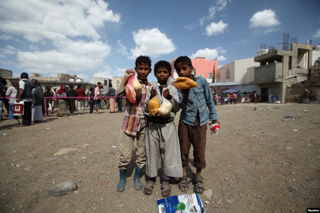 کودکان یمنی بعد از دریافت بستههای غذایی از یک مرکز توزیع غذا برای افطار