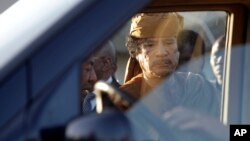 Libyan leader Moammar Gadhafi about to get into a car in Tripoli, Libya, Sunday, April 10, 2011. 