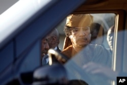 Libyan leader Moammar Gadhafi about to get into a car in Tripoli, Libya, Sunday, April 10, 2011.