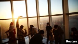 People enjoy New Year's Eve during sunset amid the coronavirus disease (COVID-19) pandemic at the Seoul Sky Observatory in Seoul, Dec. 31, 2021.