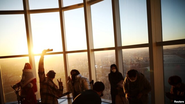 People enjoy New Year's Eve during sunset amid the coronavirus disease (COVID-19) pandemic at the Seoul Sky Observatory in Seoul, Dec. 31, 2021.