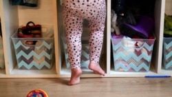 A preschooler gets up on her toes to reach into her assigned cubby at a preschool center Monday, Oct. 25, 2021, in Mountlake Terrace, Wash. (AP Photo/Elaine Thompson)