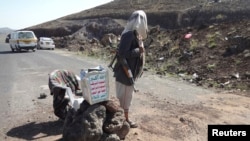A Shi'ite militant mans a checkpoint on a road in Yemen's northwestern province of Omran, June 3, 2014. 