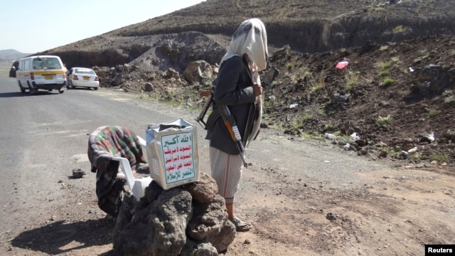 A Shi'ite militant mans a checkpoint on a road in Yemen's northwestern province of Omran, June 3, 2014. 