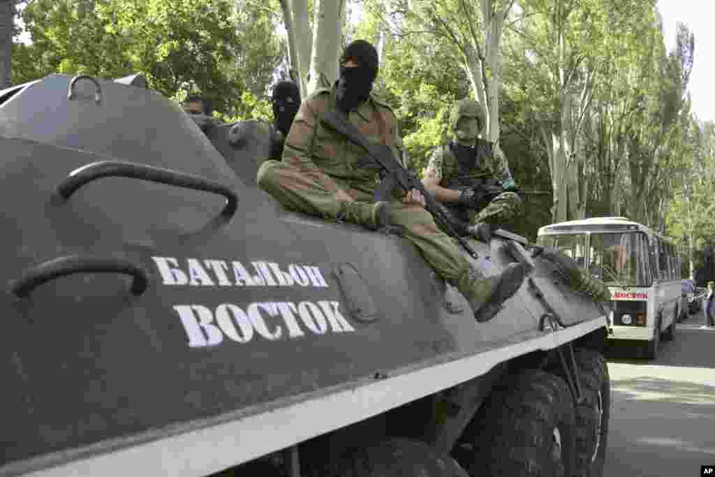 Pro-Russian gunmen sit on an armored personnel carrier with the words read "Battalion Vostok (East) " as they patrol in Donetsk, Ukraine, May 20, 2014.