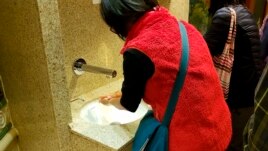 In this Monday, Feb. 3, 2020, photo taken by the passenger, another passengers wash their hands on the cruise ship Diamond Princess anchored off Yokohama, south of Tokyo. (@daxa_tw via AP)